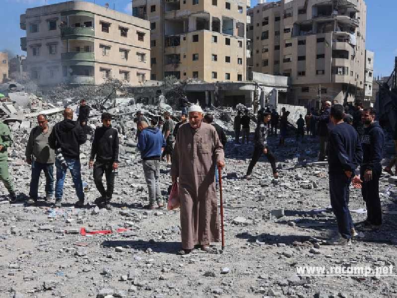 An elderly Palestinian man walks past people gaathered near the rubble of the Elias Tarazi family house, after it was destroyed in an Israeli strike in al-Sabra neighbourhood in Gaza City on March 19, 2025. (Photo by Omar AL-QATTAA / AFP) (Photo by OMAR AL-QATTAA/AFP via Getty Images)
